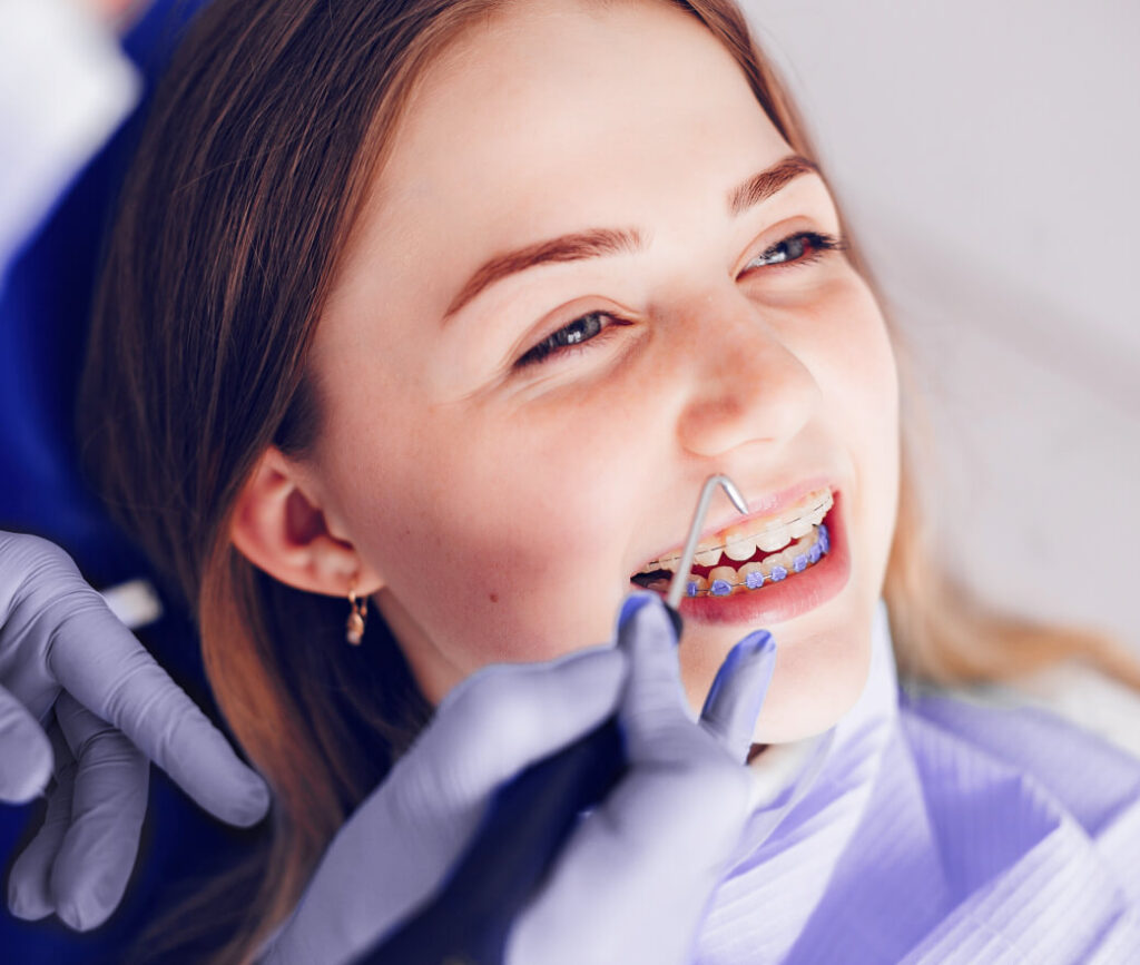 woman smiling while getting her teeth worked on at the dentist